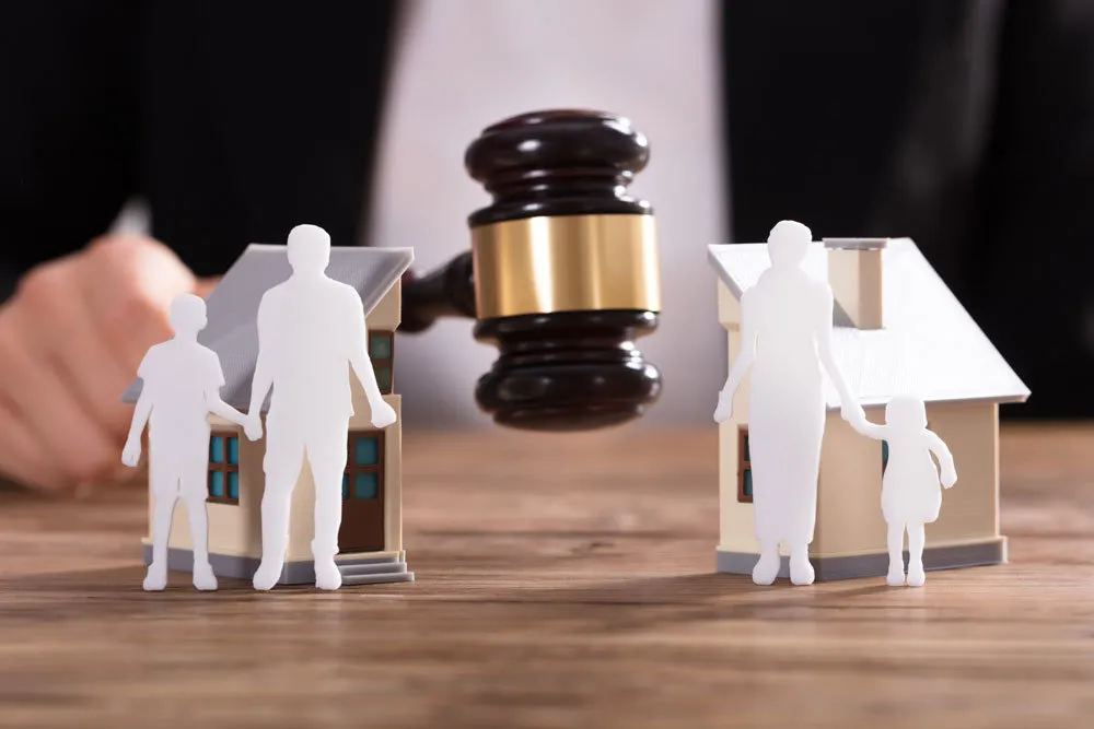 Судовий молот між сімейною парою із дітьми, що символізує сімейні справи