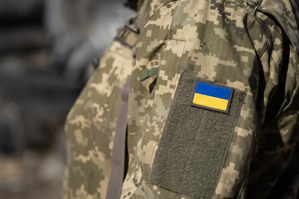 Людина у військовій формі із прапором України